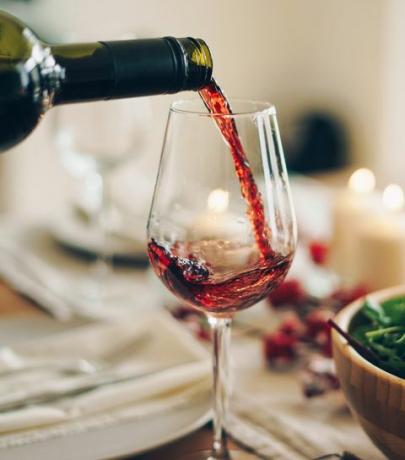 rødvin hældes i glasset ved bordet