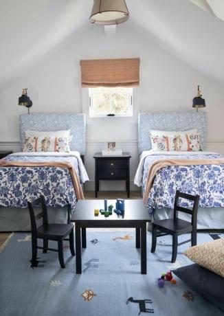 børns soveværelse, to enkeltsenge, sorte stole og bord med byggeklodser, blomsterhovedgavl