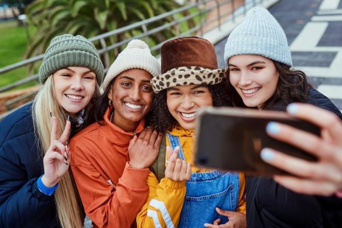 glade selfie- og pigevenner rejser i byen sammen mens de er på ferie i mexicos mangfoldighed, smiler og unge kvinder tager sjove billeder på telefonen for at poste på sociale medier mens de er på ferierejse