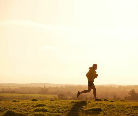 jogger løber på bakke ved solnedgang