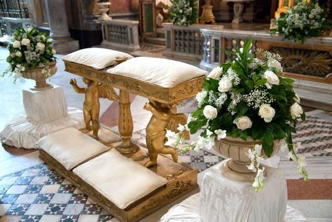 Bryllup i kirken med blomster, ornamenter og puder