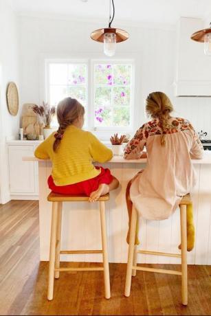 to piger, der laver hjemmearbejde på køkkenø