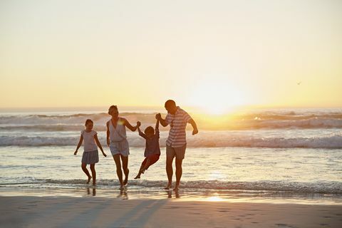 Forældre med børn, der nyder ferie på stranden