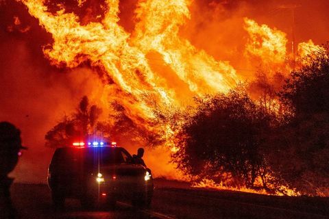 en politimand ser flammer skyde ud i luften, da ilden fortsætter med at sprede sig under bjørnebranden i Oroville, Californien den 9. september, 2020 farlige tørre vinde piskede op i Californiens rekord med at bryde skovbrande og antændte nye flammer, da hundreder blev evakueret med helikopter og snesevis af tusinder blev kastet i mørket af strømafbrydelser over det vestlige USA foto af josh edelson afp foto af josh edelsonafp via getty billeder