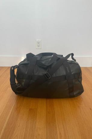 en sort taske på et trægulv