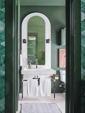badekar, grønt badeværelse, hvid håndvask og hvide håndklæder