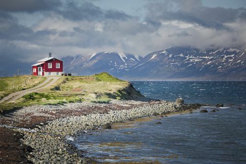 rødt hus ved siden af ​​en fjord i Nordisland