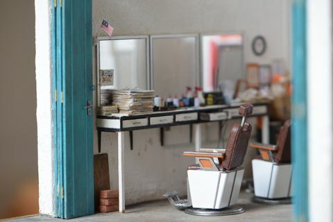 miniaturereplika af barberbutik med tre spejle, to barbershopstole og borde, der indeholder barberartikler