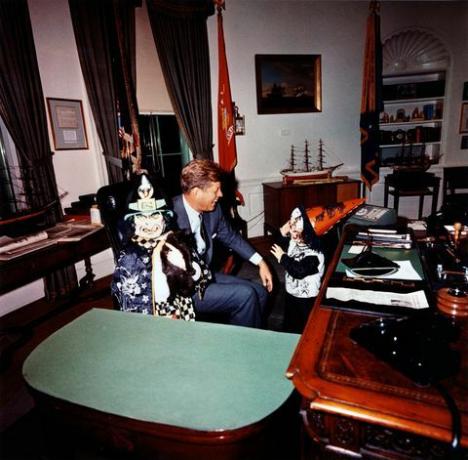 dette fotografi af cecil stoughton viser caroline kennedy og john f kennedy, jr besøger præsident john f kennedy på det ovale kontor på halloween i deres kostumer