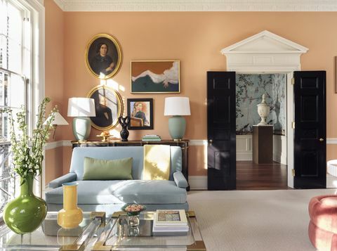 stue, orange tapet, sorte døre, blå sofa, gul og grøn vase