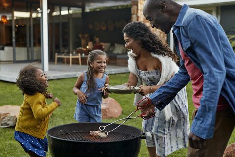 Familie madlavning på grill i deres have