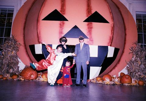 på dette fotografi, præsident jimmy carter, førstedame rosalynn carter, deres datter amy og deres barnebarn jason poserer til et gruppeportræt foran et stort græskar på den nordlige portik under et hvidt hus halloween parti