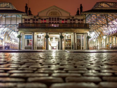 Covent Garden Piazza om natten med lys reflekterende i brosten