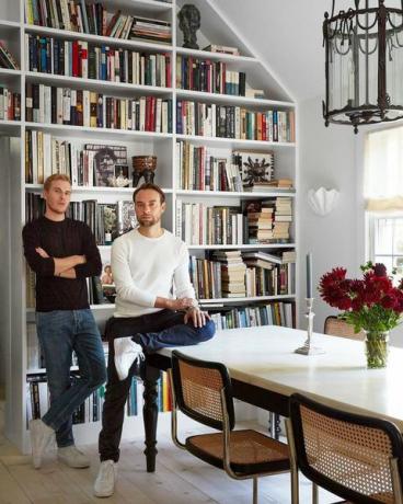 designer patrick mcgrath står i sin spisestue med partner