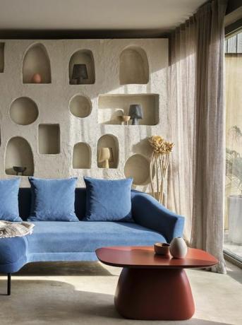 hyggelig stue med naturligt lys og blå sofa