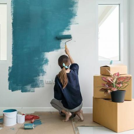 kvinde maler en mur blå
