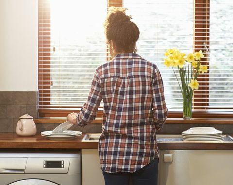 Kvinde, der vasker op porcelæn i køkkenet