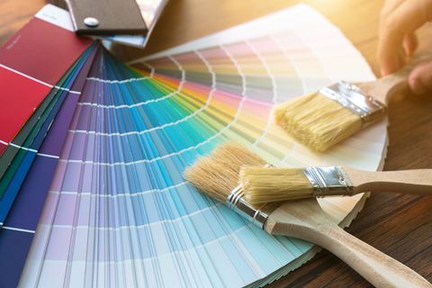 Maler- og dekoratørarbejdsbord med husprojekt, farveprøver, malerulle og pensler