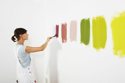 Kvinde maler farveprøver på væggen