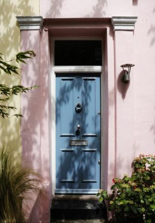 blå hoveddør, pastellyserødt ydre af traditionel britisk boligbygning